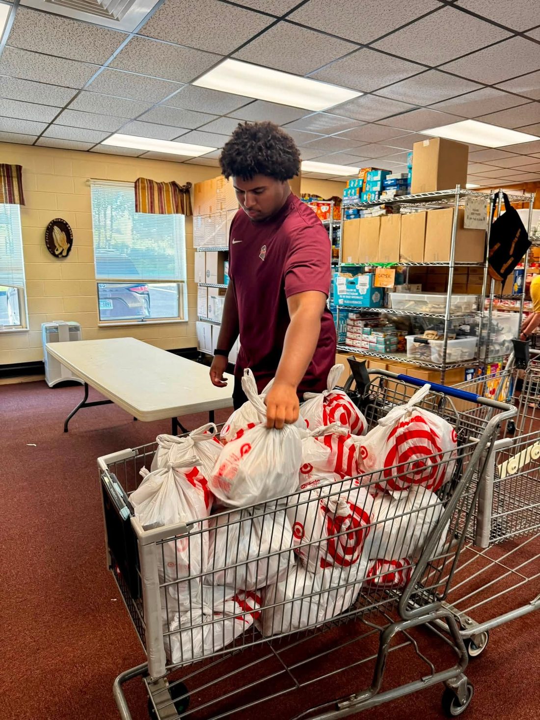 Benjamin Eziuka pushing a cart of bagged groceries at the Micah's Backpack food pantry in Blacksburg.